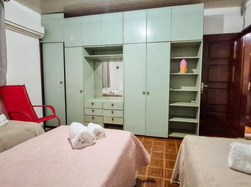 ein Zimmer mit zwei Betten und einem Schrank mit Regalen in der Unterkunft Pousada in Belém