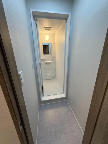 a hallway leading to a bathroom with a mirror at B cycle Double Room in Biei