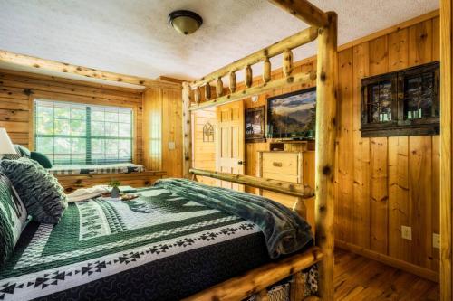 a bedroom with a bed in a log cabin at Joy's Retreat Cabin in Sevierville