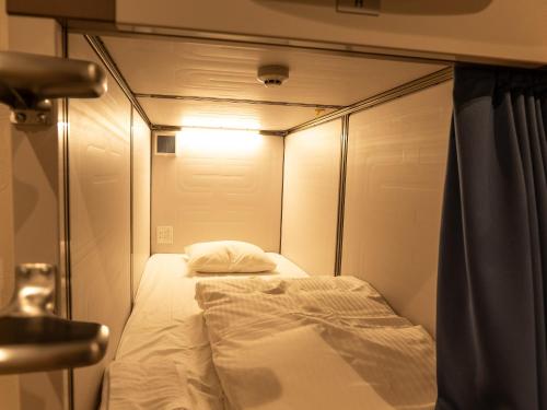 a small bedroom with a bed in a room at HOTEL PAiKAJi in Ishigaki Island
