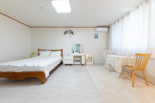a bedroom with a bed and a table and a desk at Tov Stay Atti in Pyeongtaek