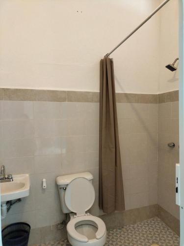 a bathroom with a toilet and a sink at Casa Papalo in Palenque