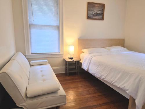 a bedroom with a bed and a couch and a window at Entire Beautiful 1BR for You! [R] in Whitestone