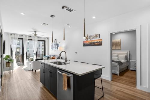 a kitchen with a sink and a living room at The Odyssey Apartments by AvantStay in Nashville