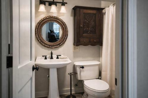 a bathroom with a toilet and a sink and a mirror at Honeymoon Cottage Chateau DuMont in Banner Elk
