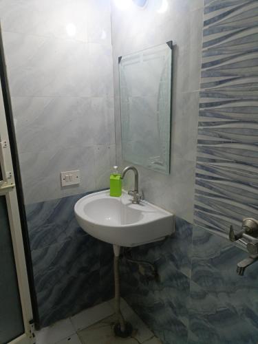 a bathroom with a sink and a mirror at Urban Cozy 2 bhk in Ghaziabad