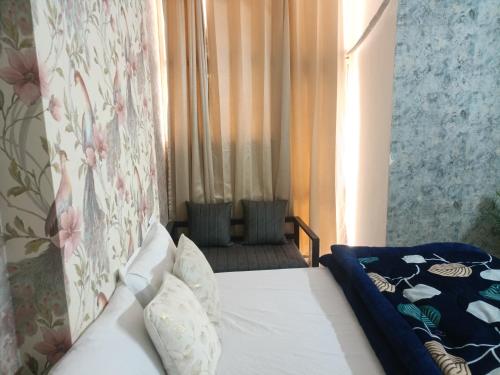 a bedroom with a bed and a window at Urban Cozy 2 bhk in Ghaziabad