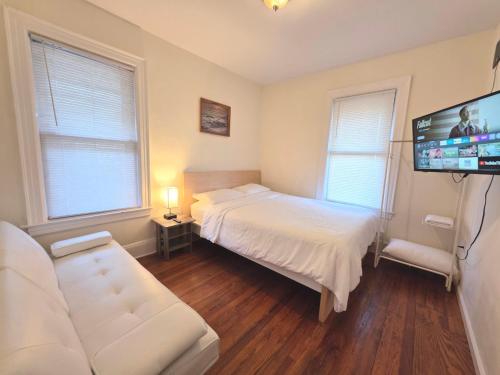 a bedroom with a bed and a flat screen tv at Entire Beautiful 2BR Private Apartment [R] in Whitestone