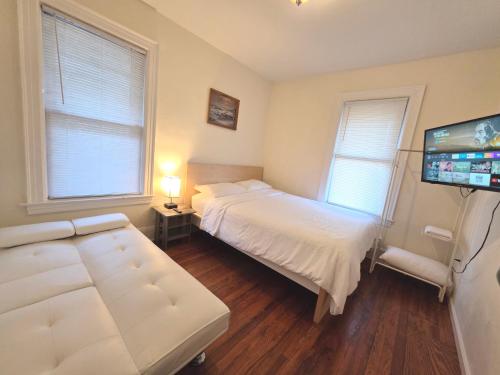 a bedroom with two beds and a flat screen tv at Entire Beautiful 2BR Private Apartment [R] in Whitestone