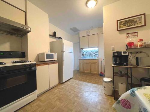 a small kitchen with a stove and a refrigerator at Entire Beautiful 2BR Private Apartment [R] in Whitestone
