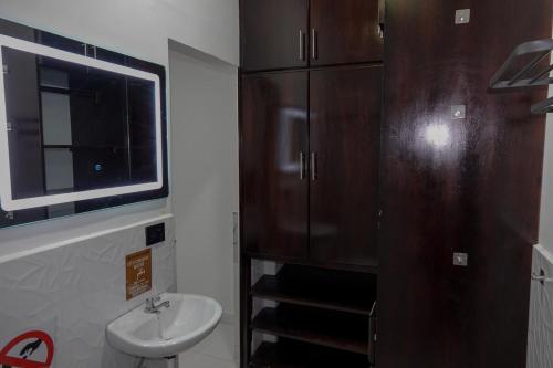 a bathroom with a sink and a brown refrigerator at San Cristóbal Surf House II in San Cristóbal