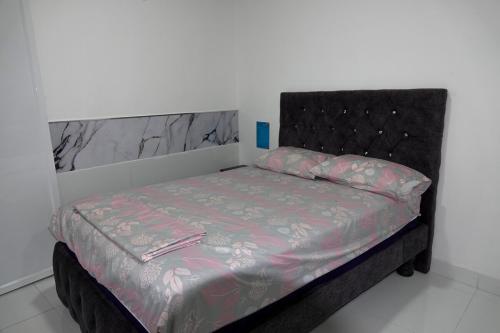 a bed with a black headboard in a room at San Cristóbal Surf House II in San Cristóbal