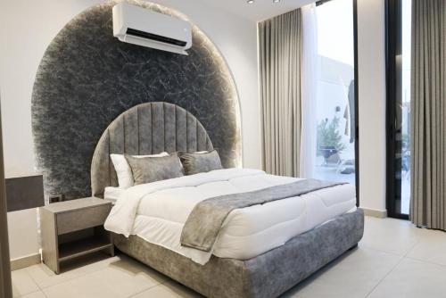 a bedroom with a large bed with a wall at Amora Villa in Al Rama