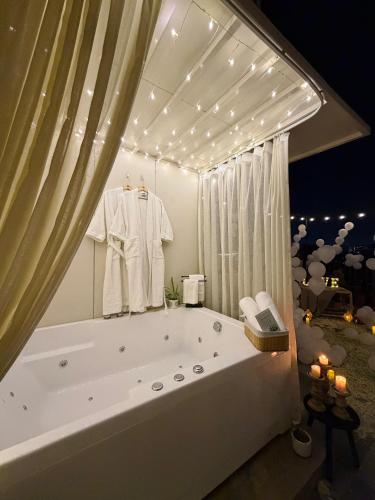 a bathroom with a large bath tub with a robe at Chérie Bliss Loft in Jaipur