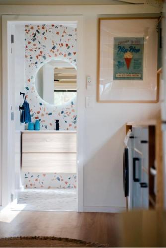 a kitchen with a white door and a mirror at Mangapiko Cabin in Pirongia