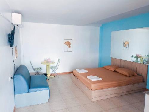 a bedroom with a bed and a blue chair at แฟนตาซีรีสอร์ท สระบุรี in Ban Khok Sawang (1)