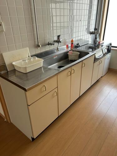 a kitchen with a sink and a counter top at Toolate Guesthouse Toyama in Toyama