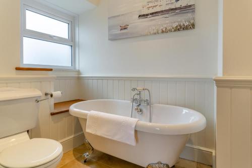 a white bathroom with a tub and a toilet at 5 Bed in Wath oc-w28415 in Wath