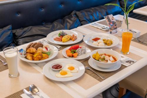 a table with plates of breakfast food on it at Centara Hotel Hat Yai in Hat Yai