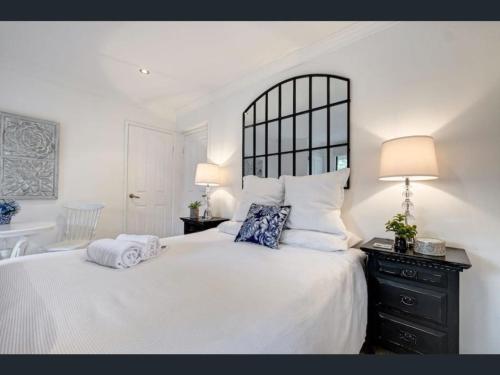 a bedroom with a large white bed with two pillows at River Suite Studio with Lovely Garden - Walk to River in Perth