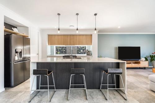 a kitchen with a island with bar stools and a tv at Sunhaven in North Creek