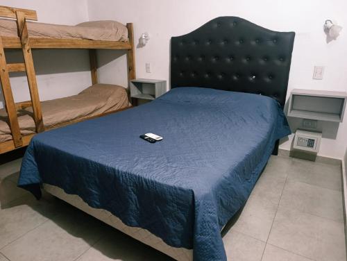 a bedroom with a bed with a remote control on it at Complejo Bienteveo in San Antonio de Arredondo
