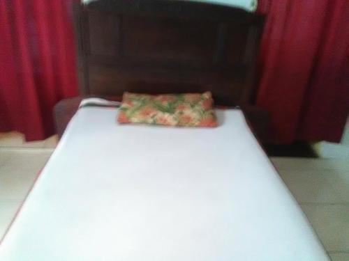 un letto bianco con un cuscino sopra di Stanley Hotel a Cap-Haïtien