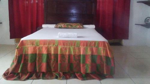 un letto con una coperta colorata sopra di Stanley Hotel a Cap-Haïtien