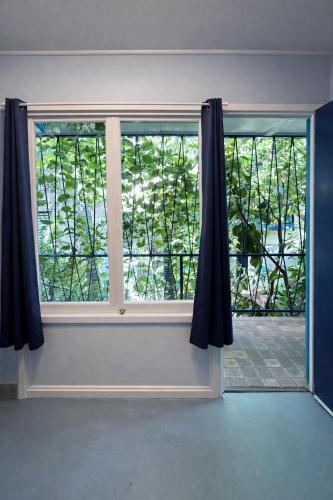 an open window with black curtains in a room at Zen Hostel in Townsville