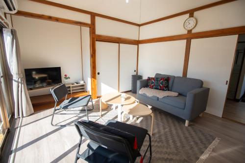 a living room with a blue couch and a table at Tsugumi Entire House Rental in Matsumoto in Matsumoto