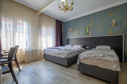 a bedroom with two beds and a chandelier at suites beyazıt in Istanbul