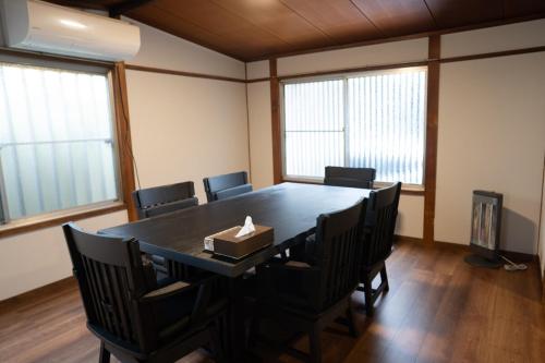 a conference room with a table and chairs and windows at 響-Garden House- in Toyonaka