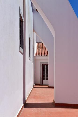 an empty hallway of a white building with a window at Pousada Convento de Beja in Beja