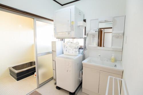a kitchen with a refrigerator and a sink at Tsugumi Entire House Rental in Matsumoto in Matsumoto