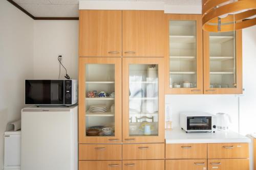 a kitchen with wooden cabinets and a refrigerator at Tsugumi Entire House Rental in Matsumoto in Matsumoto