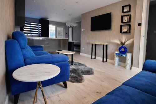 a living room with blue couches and a tv at Liverpool House Near City Centre in Liverpool