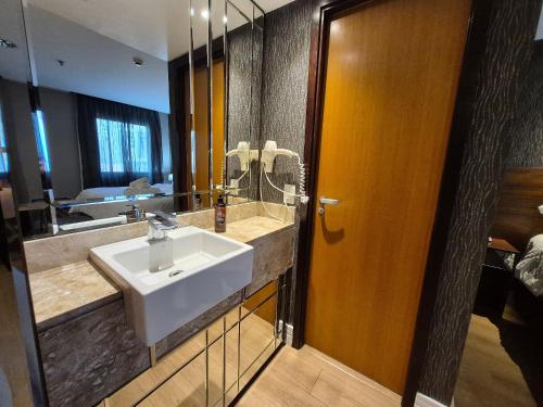 a bathroom with a sink and a mirror at Flat Hotel Executivo Ibirapuera Moema (Apto 844B) in São Paulo