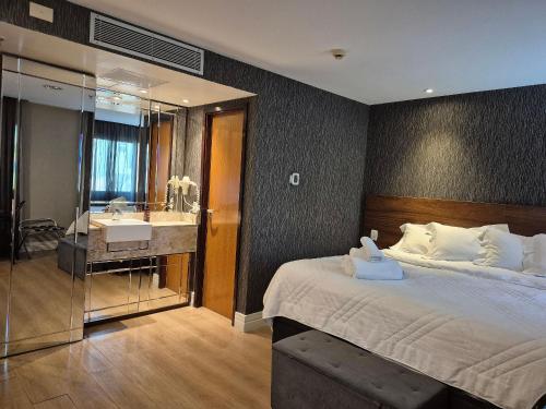 a bedroom with a bed and a bathroom with a sink at Flat Hotel Executivo Ibirapuera Moema (Apto 844B) in São Paulo