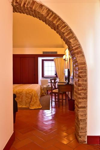 an archway in a bedroom with a bed and a desk at Pousada Convento de Beja in Beja