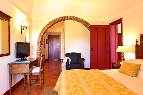 a hotel room with a bed and a television at Pousada Convento de Beja in Beja