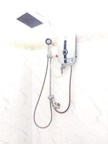 a shower with a shower head in a bathroom at Thida Villa in Siem Reap