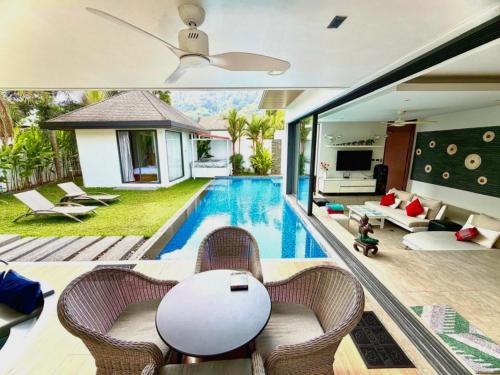 a villa with a swimming pool and a living room at VILLA Pak Dang in Phuket