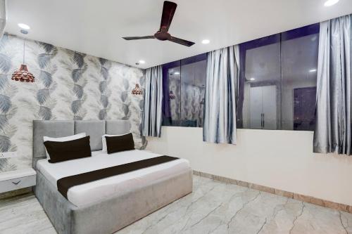 a bedroom with a bed and a ceiling fan at Super Townhouse DSIDC Bawana Formerly Kanhaiya Residency in Delhi