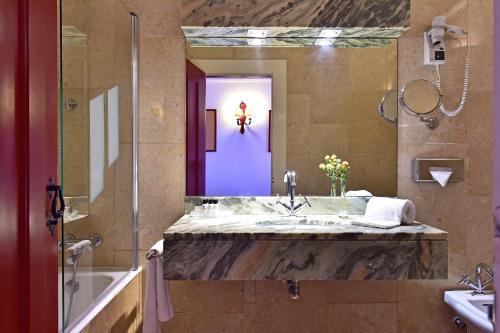 a bathroom with a sink and a large mirror at Pousada Convento de Beja in Beja