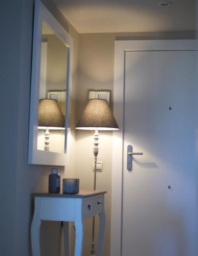 a room with a lamp and a table with a mirror at Apartamentos Santa Clara in Calpe