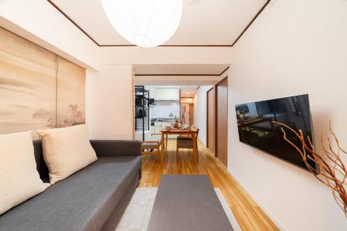 a living room with a couch and a tv at Fujimi apartment601 in Tokyo