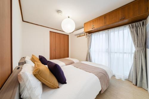 a bedroom with two beds and a window at Fujimi apartment601 in Tokyo