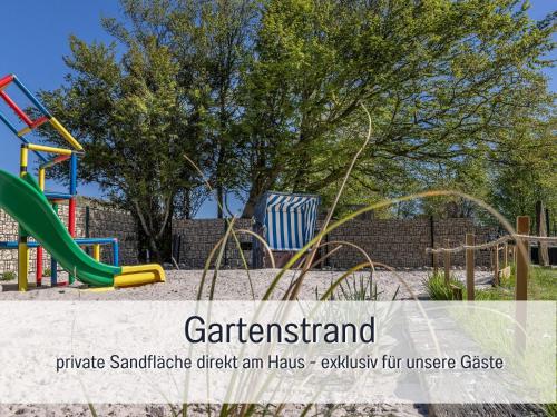 a playground at a park with a slide at Ferienwohnung KIEK RUT - Gartenstrand, Wallbox & Sauna, alles für die Familie, zusätzlicher Loft in Harlesiel in Wittmund