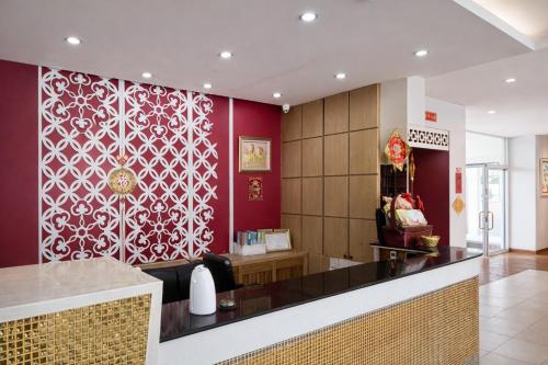 a restaurant with a bar with a red wall at Smile Bed Hotel in Sathani Khlong Rian