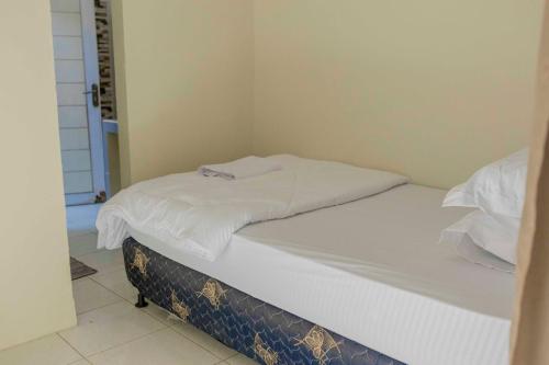 a unmade bed in a small room with at Sandik Local Stay in Midang